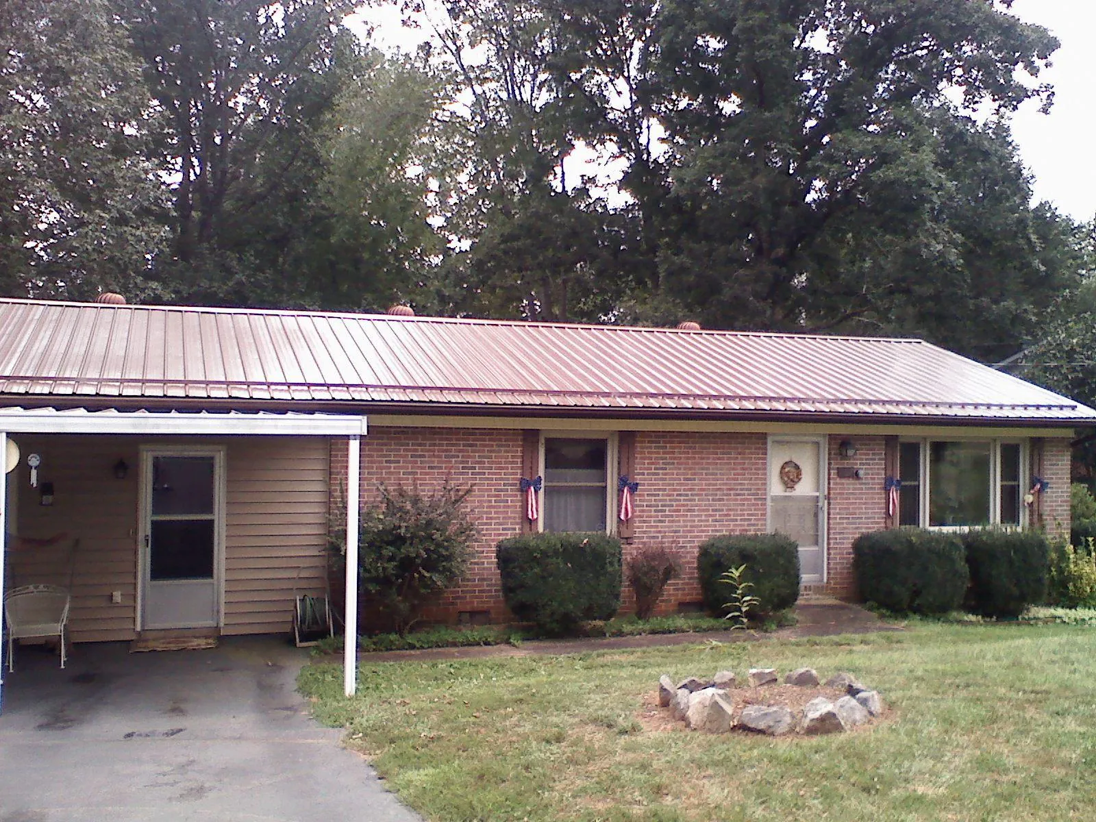 Bronze metal roof and carport on a brick ranch home — Roof Repair work by our crew in North Bend